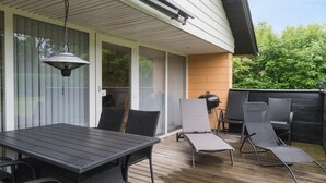 A covered patio with a table and chairs, a grill, and a view of a wooded area. - Gorgeous home in Hemmet with WiFi (Hemmet)
