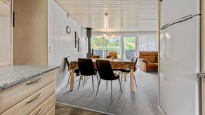 A modern kitchen with a dining area, featuring a granite countertop, wooden cabinets, and a dining table with chairs. - Gorgeous home in Hemmet with WiFi (Hemmet)