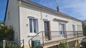 A two-story building with a balcony, a mailbox, and a door marked with the number 20. - Green holidays in the countryside (La Machine)