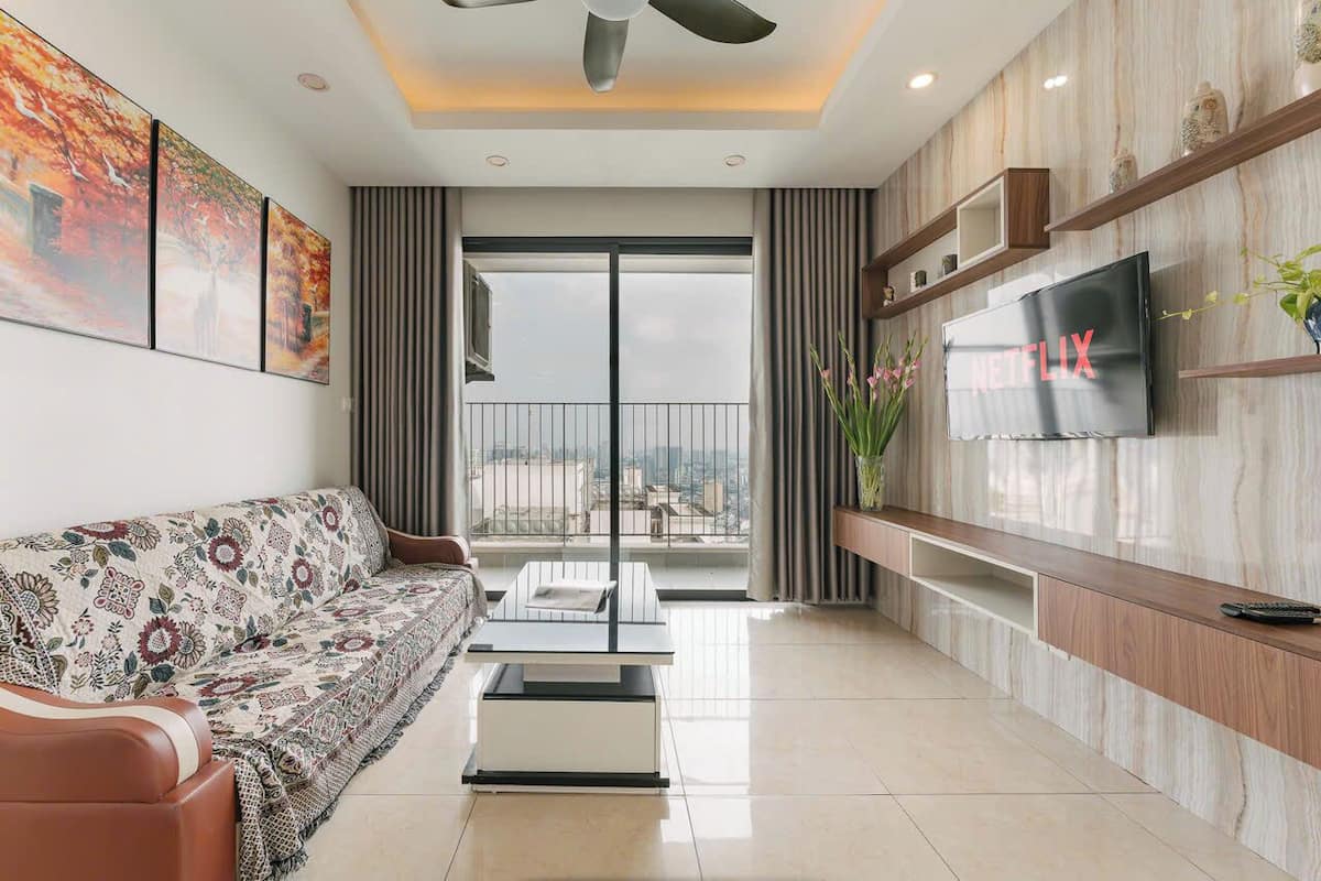 A modern living room with a sofa, coffee table, and a TV mounted on the wall.