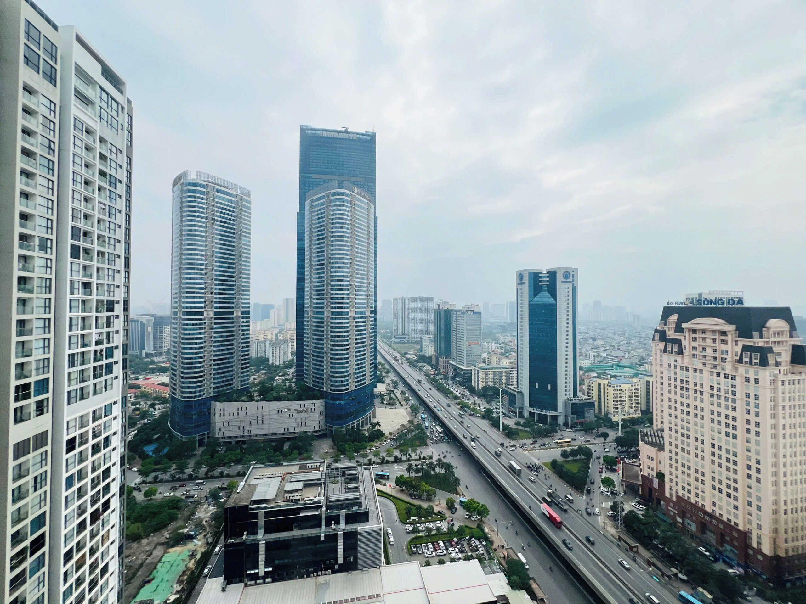 A high-rise urban area with modern skyscrapers, a busy highway, and a mix of commercial and residential buildings.