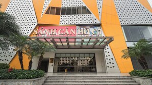 A hotel entrance with a modern design, featuring geometric patterns and a prominent entrance with steps leading up to it.