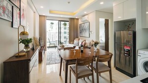 A modern kitchen with a built-in refrigerator, a washing machine, and a dining area with a table and chairs.