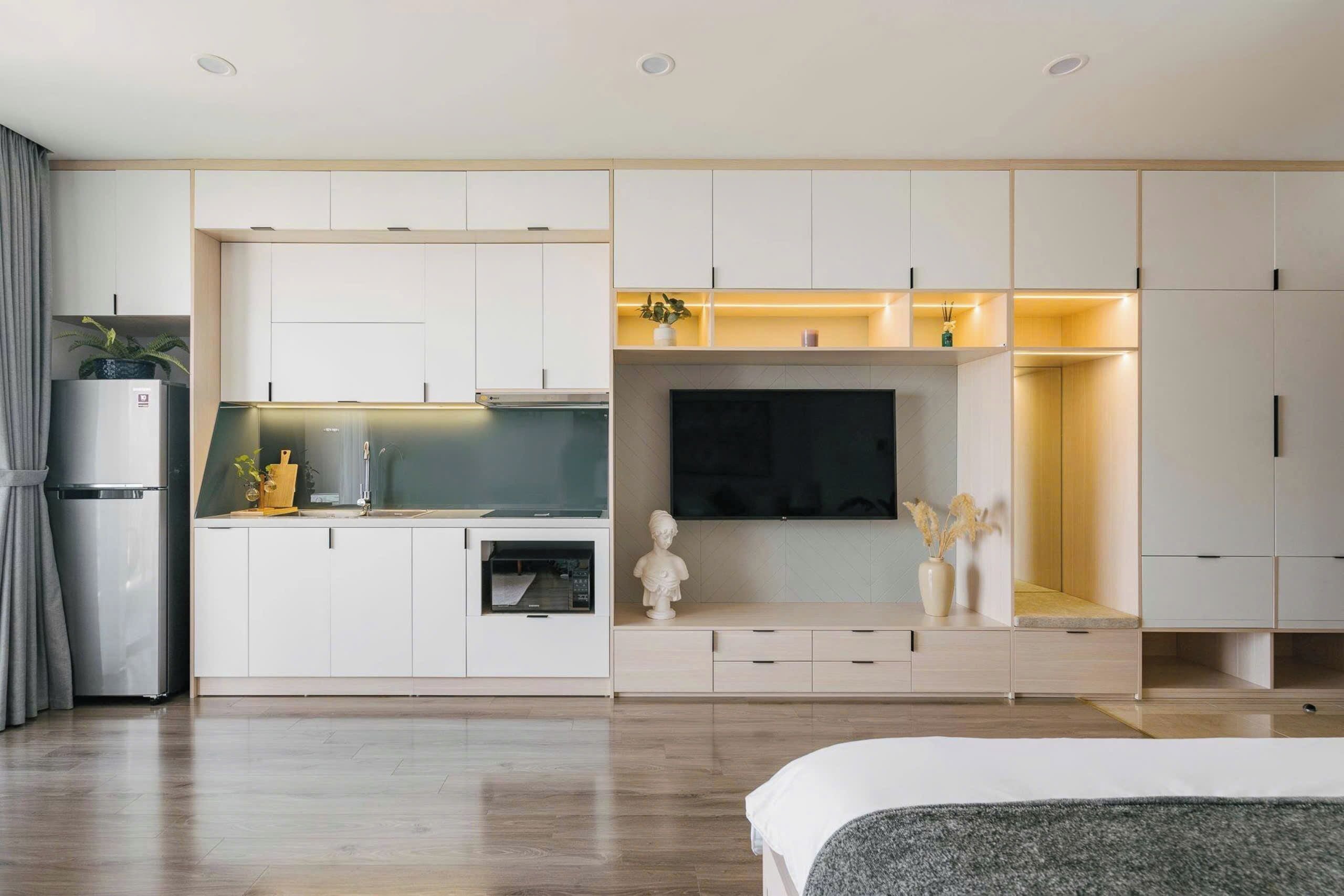 A modern kitchen with built-in appliances, a dining area, and a TV.