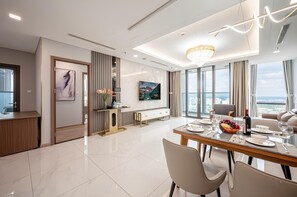 Familie appartement, 4 slaapkamers, balkon, uitzicht op de stad | Woonruimte | Een 80-inch flatscreentelevisie met kabelzenders en boeken