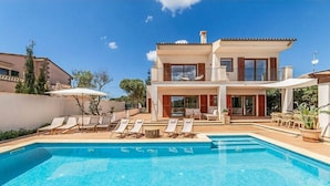 A two-story house with a swimming pool, lounge chairs, and a patio area. - Stunning home in Llucmajor with private swimming pool, can be inside or outside (Llucmajor)