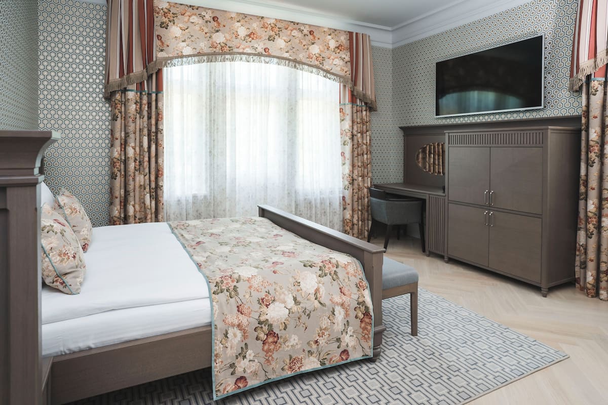 Une chambre à coucher avec un lit, un bureau et un téléviseur.