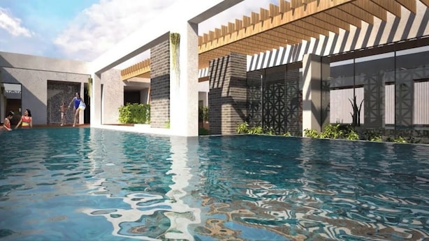 Ein moderner Poolbereich mit klarem Wasser, umgeben von moderner Architektur und viel Grün.