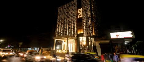 Un edificio moderno con una fachada distintiva y una entrada iluminada durante la noche.