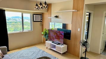 Departamento Confort, vista parcial al océano | Área de sala de estar | Televisión LCD de 55 pulgadas con canales digitales y Netflix