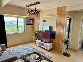 Apartamento Confort, vistas parciales al mar | Zona de estar | Televisión LCD de 55 pulgadas con canales digitales, Netflix