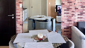 A compact living space with a dining area, a kitchenette, and a door leading to another room. - Wonderful One Bedroom at Avida No. 40 (Iloilo)