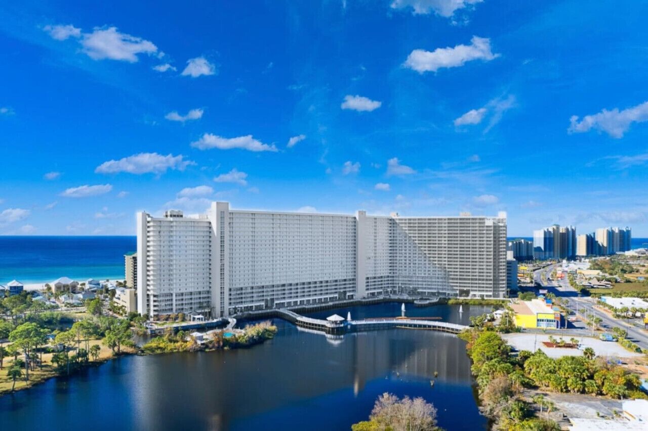A large hotel with multiple high-rise buildings, a marina, and a view of the ocean.