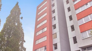A multi-story building with a red and white facade, featuring a central vertical structure. - Rosalia - Stylish living, central experience (Kaiserslautern)