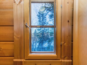 A wooden door with a window, a door handle, and a latch. - Alakoski by Interhome (Inari)