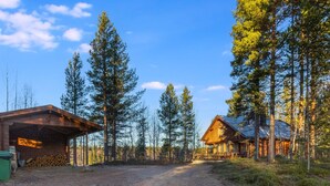 A rustic cabin with a dirt driveway, surrounded by tall pine trees. - Alakoski by Interhome (Inari)
