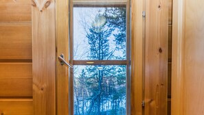 A wooden cabin door with a window revealing a forest view. - Alakoski by Interhome (Inari)