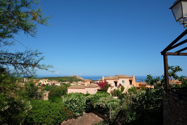 A coastal village with traditional architecture, a stone wall, and a view of the sea.