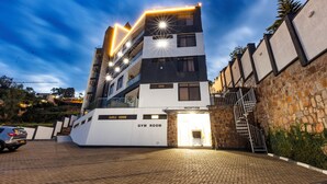 Un hôtel à plusieurs étages, avec une réception au rez-de-chaussée et une salle de sport dont l’emplacement est indiqué sur la façade.