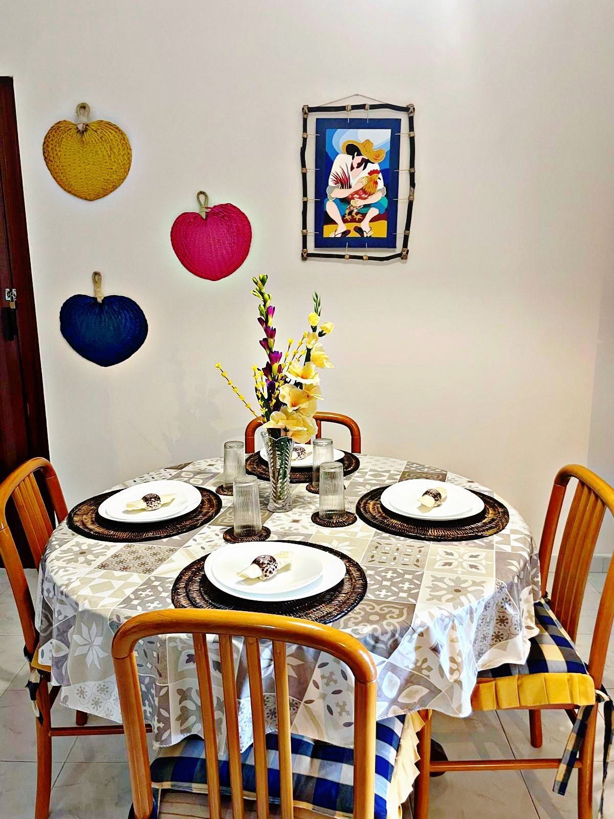Une table à manger recouverte d’une nappe à motifs, entourée de chaises en bois.