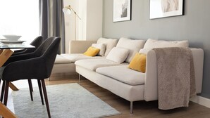 A modern living room with a sofa, two armchairs, a coffee table, and a floor lamp. - Stylish 2BR Apartment, Town Centre, Free Parking (Hatfield)