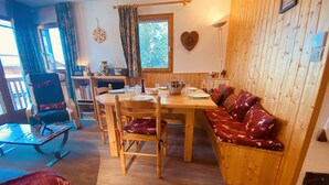 A cozy room with a wooden dining table, chairs, and a bench with patterned cushions. - Cozy apartment for 6, near slopes, includes parking (Peisey-Nancroix-Plan Peisey)