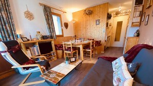 A cozy living room with a sofa, a chair, a small table, and a television. - Cozy apartment for 6, near slopes, includes parking (Peisey-Nancroix-Plan Peisey)