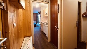 A hallway with wooden walls, a white door with a heart-shaped decoration, and a small table with a floral tablecloth. - Cozy apartment for 6, near slopes, includes parking (Peisey-Nancroix-Plan Peisey)