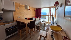 A compact living space with a wooden interior, a dining area, and a view of the outdoors.
