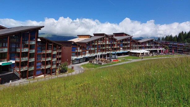 A hotel with multiple floors, balconies, and a restaurant area.