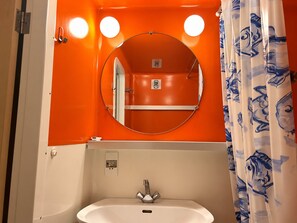 A bathroom with a white sink, a mirror, and an orange wall. - Arc 1800 - 5 pers apartment, balcony, wifi (Les Arcs 1800)