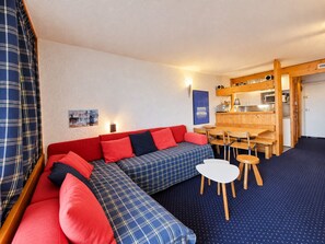 A compact living space with a sofa, a small dining table, and a kitchenette area. - Arc 1800 - 5 pers apartment, balcony, wifi (Les Arcs 1800)
