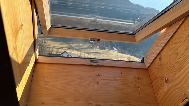 A skylight with a view of a hilly landscape. - Cazare Apuseni  Pensiune cu ciubăr (Vidra)