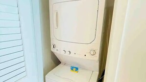 A compact laundry room with a washing machine and dryer. - Ocean-View Corner 1BR-1BA - 18th Floor, LYFE Resort & Residences (Hollywood)