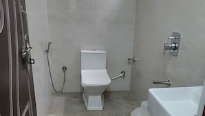 Une salle de bain avec des toilettes, une douche et un lavabo.
