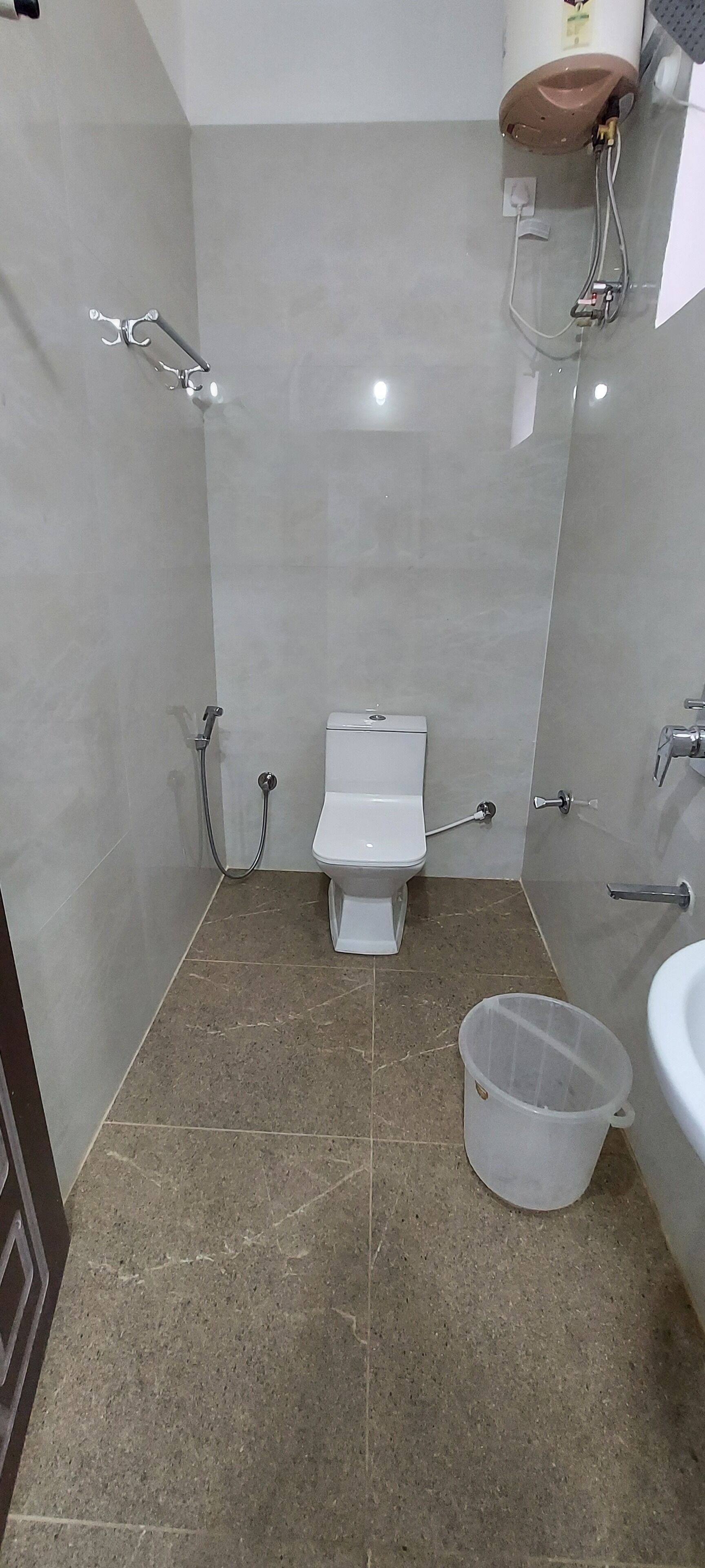 Une petite salle de bain moderne, équipée de toilettes, d’une douche et d’un lavabo.