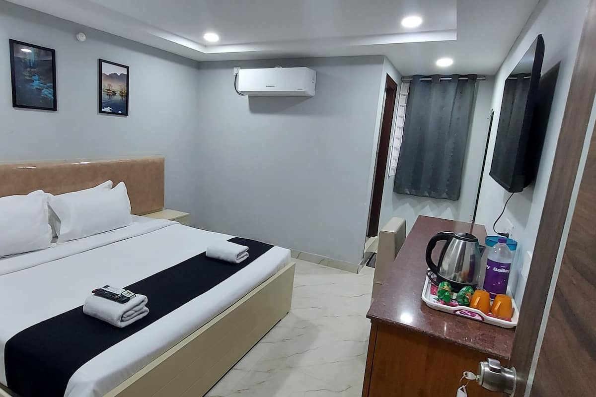 Une chambre d’hôtel équipée d’un lit, d’une table de chevet, d’un climatiseur et d’un téléviseur.