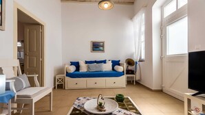 A cozy living room with a sofa, a coffee table, and a television. - Cycladic home in Adamas, Casa Nostalgia, Greece (Milos)