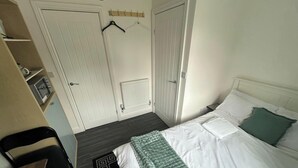 A hotel room with a bed, a chair, a desk, and a wardrobe. - Private Room, Sleeps 2 With Ensuite & Parking (Birmingham)