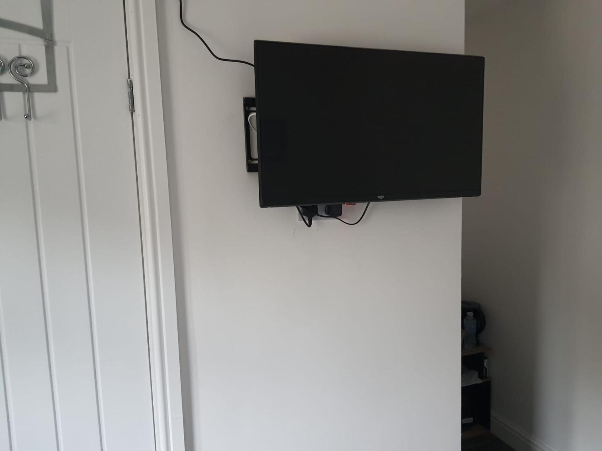 A flat-screen TV mounted on a white wall.