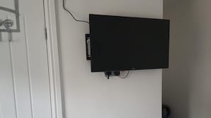 A flat-screen TV mounted on a white wall. - Private Room, Sleeps 2 With Ensuite & Parking (Birmingham)