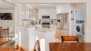 A modern kitchen with white cabinetry, stainless steel appliances, and a central island. - Historic Appleton Mansion-Sleeps 13 & Free Parking (Appleton)