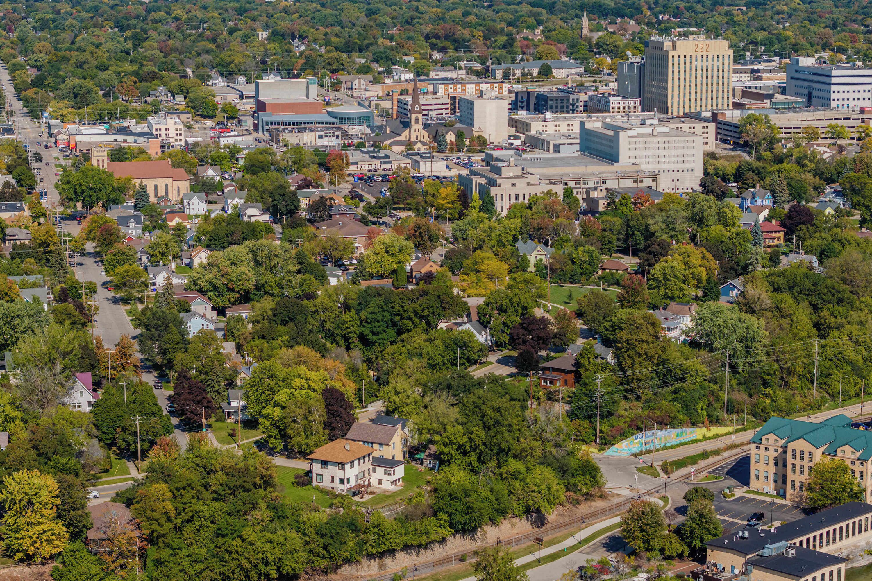An aerial view of a town with various buildings, roads, and greenery.