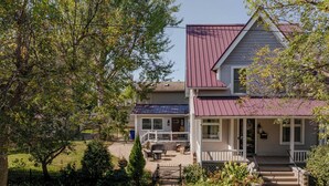 A two-story house with a red roof, a front porch, and a small garden. - Historic Appleton Mansion-Sleeps 13 & Free Parking (Appleton)