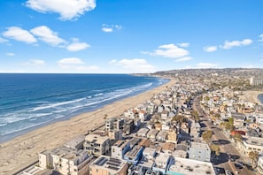 Un paysage urbain côtier avec une plage et des bâtiments très rapprochés les uns des autres.