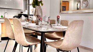 Un comedor moderno con una mesa redonda, seis sillas y un jarrón de flores.