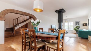 A dining area with a wooden table, chairs, and a vase of flowers.