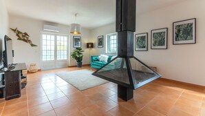 A spacious living room with a fireplace, a sofa, and a television.