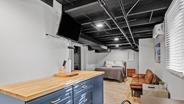 A compact living space with a kitchenette, a bed, a sofa, and a dining area.