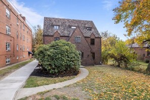 A two-story brick building with a sloped roof and dormer windows. - The Walnut Suites - The Hidden Suite (Pittsburgh)